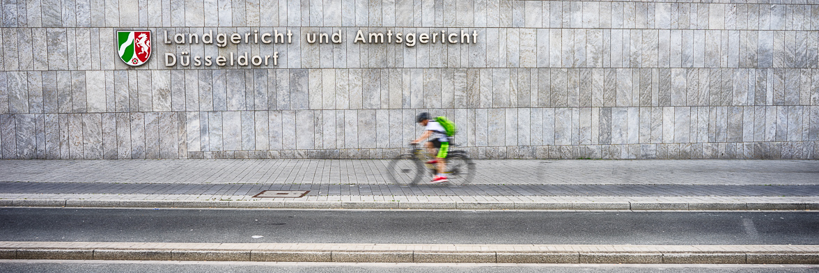 Fahrradfahrer vor dem Amtsgericht Gebäude in Düsseldorf